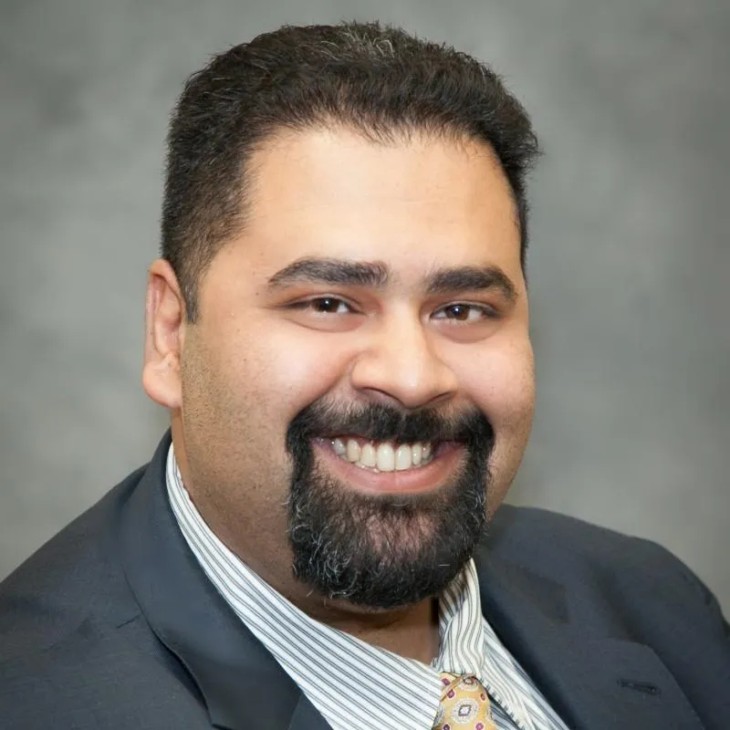 A man with a beard and suit jacket